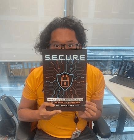 S.E.C.U.R.E. Book Cover - Mathew Clark holding the practical cybersecurity guide